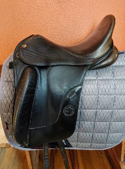 A black leather Hennig Dressage Saddle - UD184 on a grey saddle.