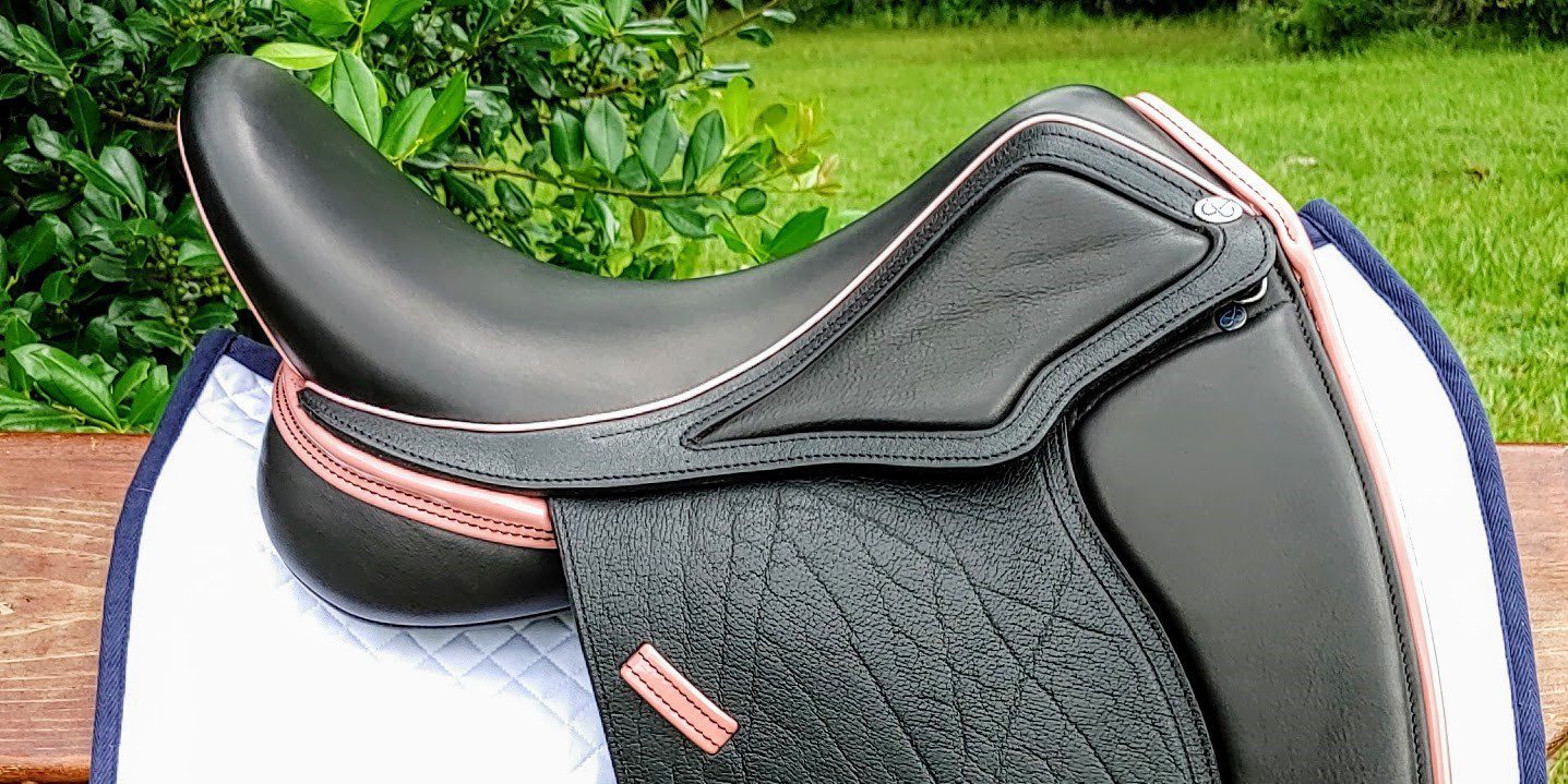 A custom black leather saddle with pink stitching.