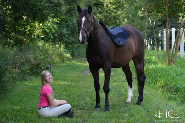 A girl sitting on the ground next to a ThinLine Endurance/Drop Rigging Fleece Pad.