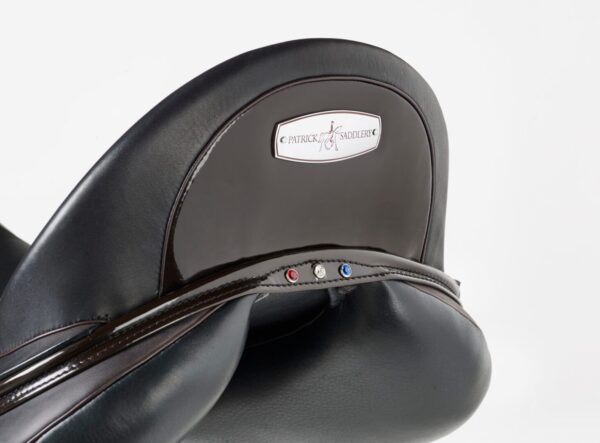 A close up of a black Patrick Liberty Dressage saddle with a logo on it.