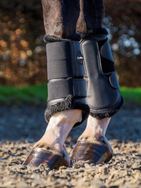 The feet of a horse in a pair of LeMieux Fleece Lined Brush Boots.