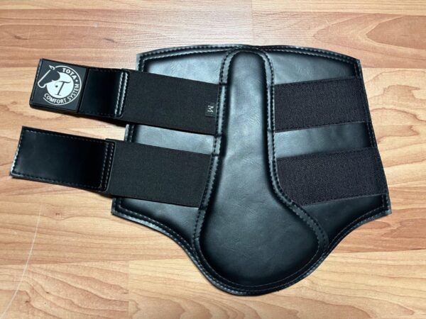 A black leather Tota Comfort Neoprene Sport Boot on a wooden floor.