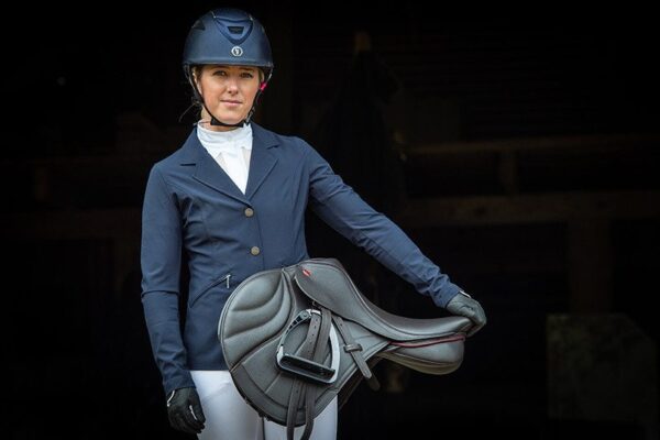 A woman in an equestrian outfit holding a Kent & Masters Competition Series Dual-Flap Jump.