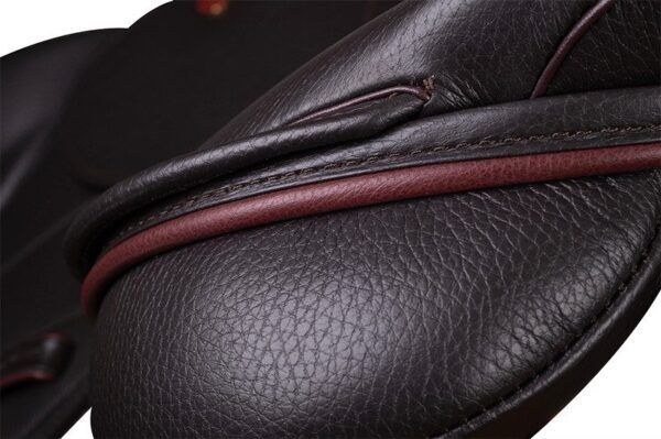 A close up of a Kent & Masters Competition Series Dual-Flap Jump saddle with red stitching.
