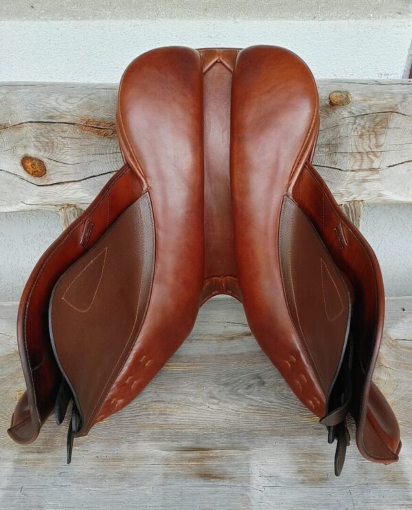 A Black Country Hunter/Jumper UC256 saddle on a wooden table.