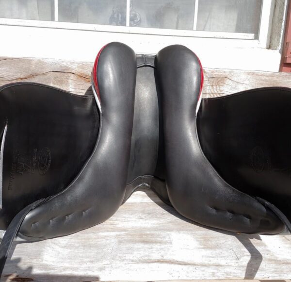 A pair of Ryder Excellence Monoflap Dressage R32 saddles sitting on a wooden bench.