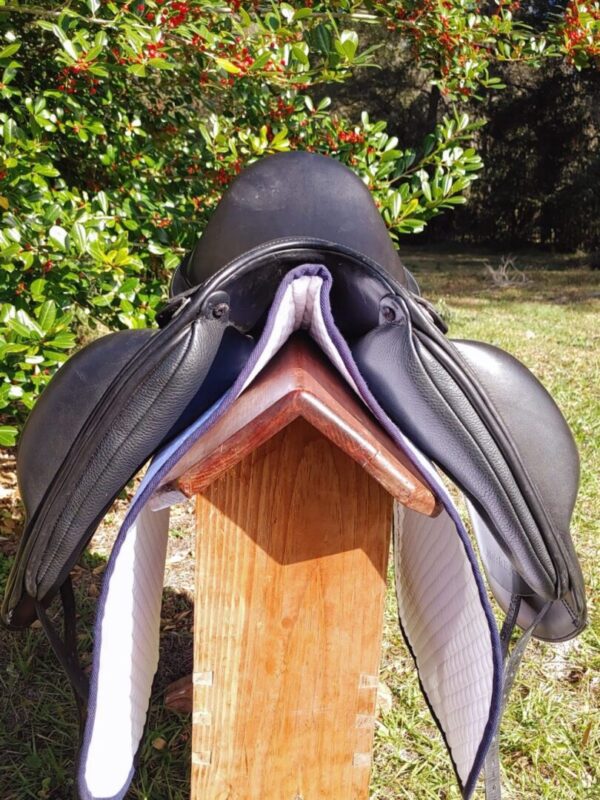 The Ryder Panamera Monoflap Dressage - R40 saddle sitting on top of a wooden post.