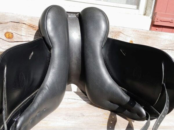 A pair of Ryder Panamera Monoflap Dressage - R40 saddles sitting on a wooden bench.