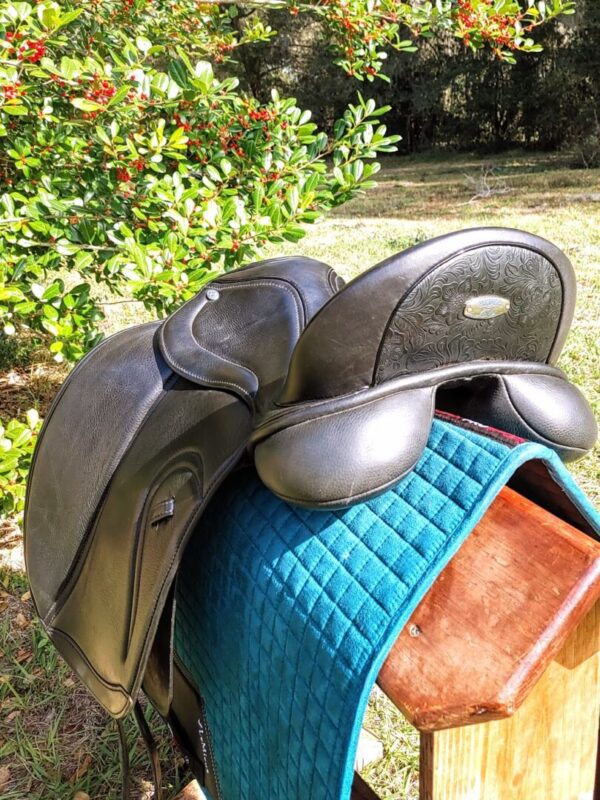 A Ryder Baroque Dual Flap Dressage - DEMO R1 saddle sitting on a wooden bench.