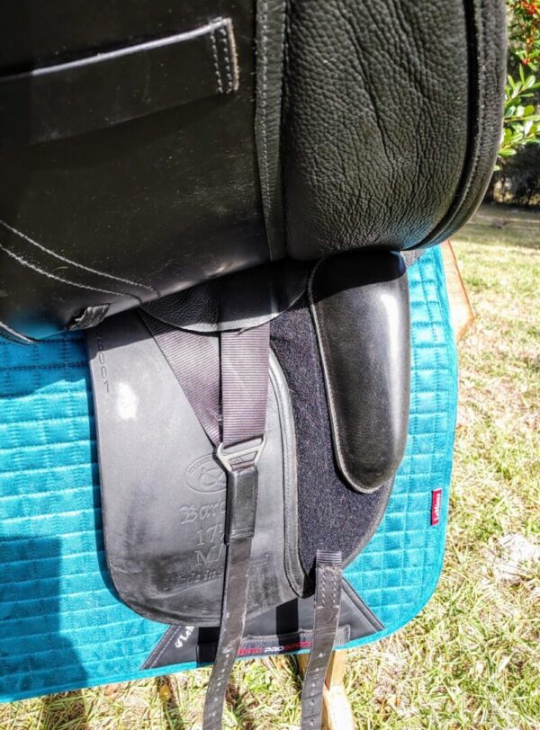 A black Ryder Baroque Dual Flap Dressage - DEMO R1 with a blue blanket on top of it.