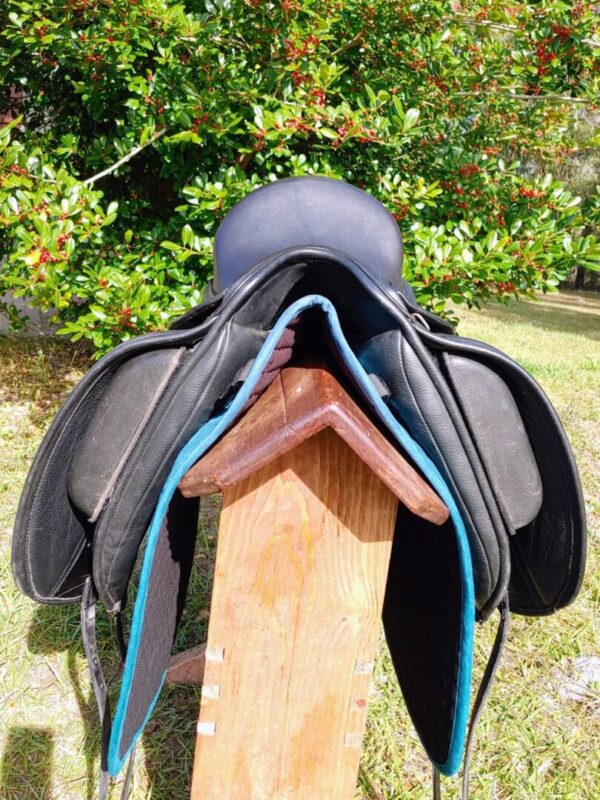 The back of a Ryder Baroque Dual Flap Dressage - DEMOR1 saddle sitting on top of a wooden board.