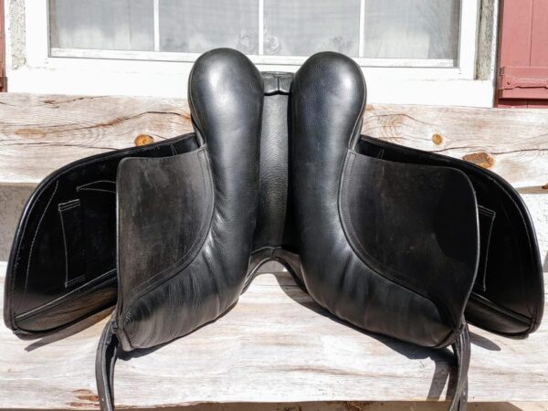 A pair of Ryder Baroque Dual Flap Dressage - DEMO R1 saddles sitting on a bench.