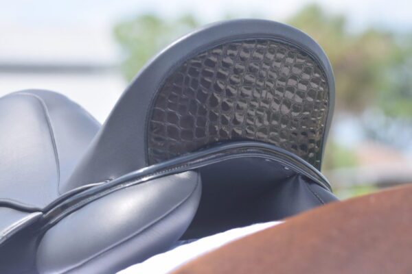 A close up of a Tota Freedom PRO 2 Dressage Saddle with a black leather seat.