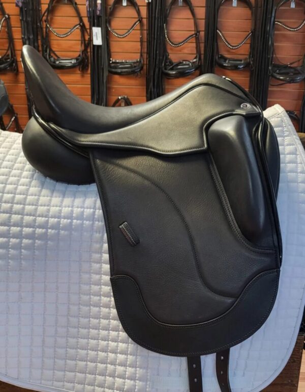 A Tota Freedom PRO 3 Dressage saddle sitting on a rug in a store.