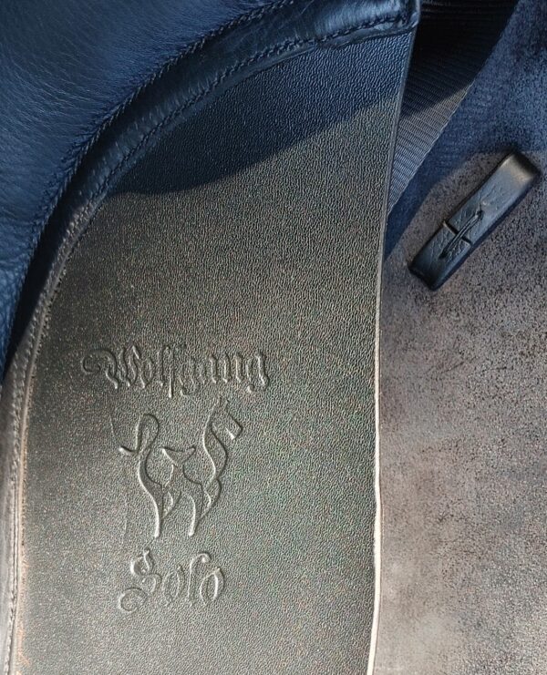 A Custom Wolfgang Solo Dressage UC259 seat with a logo on it.