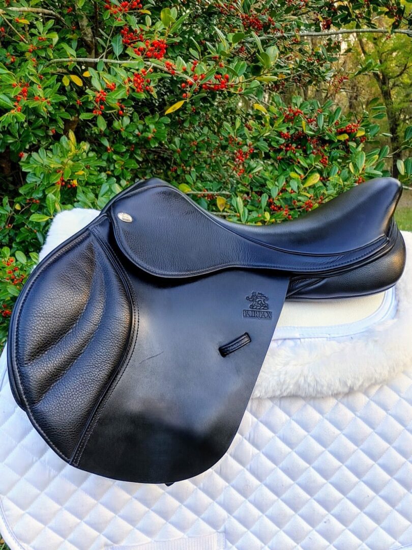 A Fairfax Classic Jump / UC242 saddle sitting on top of a white blanket.