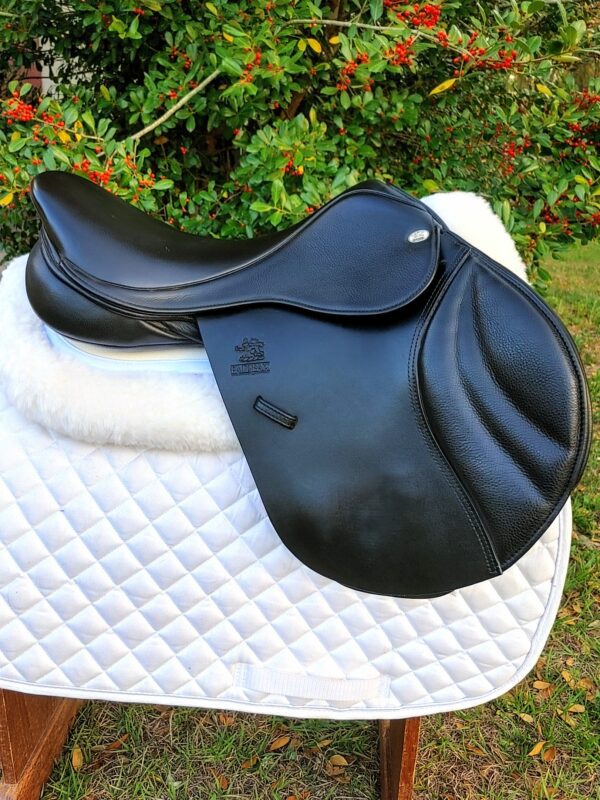 A Fairfax Classic Jump / UC242 saddle sitting on top of a white blanket.