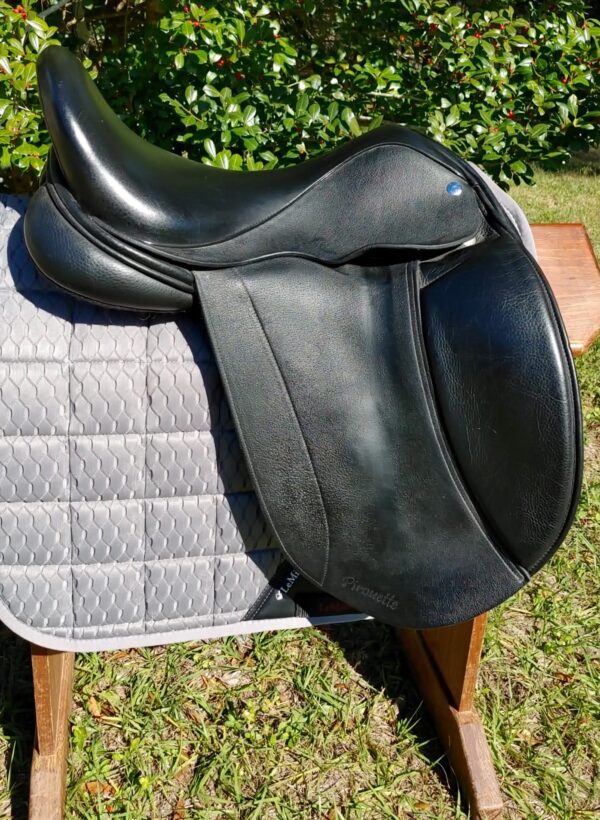 A Frank Baines Pirouette Monoflap Dressage – UC272 saddle sitting on top of a wooden bench.