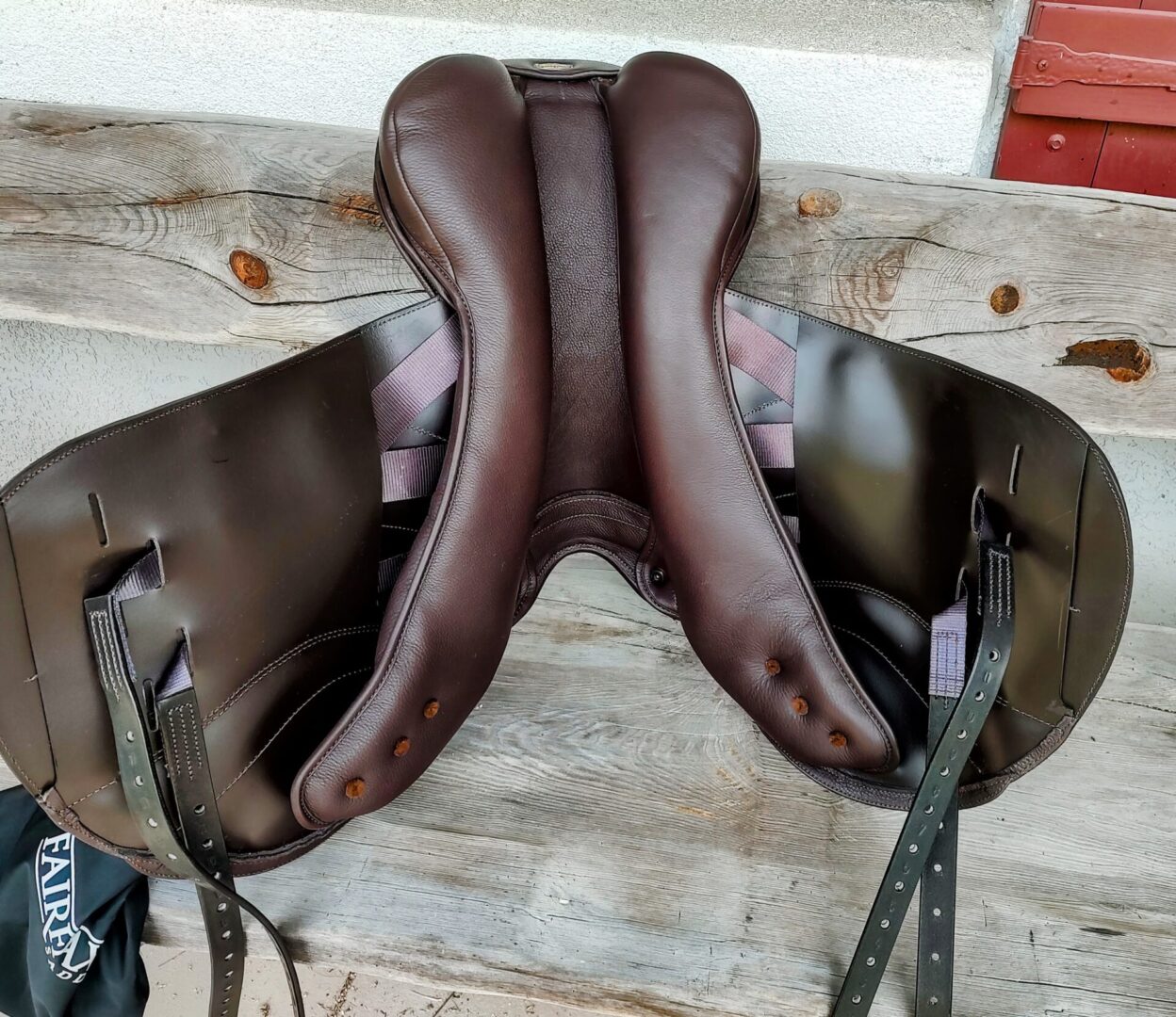 Underside of a brown leather saddle.