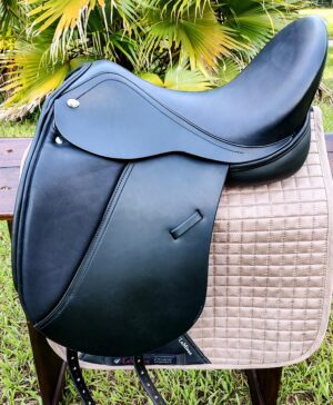 Black dressage saddle on a quilted pad.