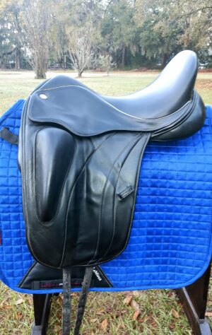 Close-up black dressage saddle with quilted pad