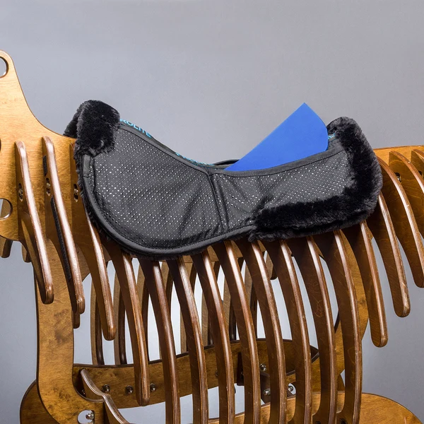 Black fur-trimmed saddle pad on wooden rack