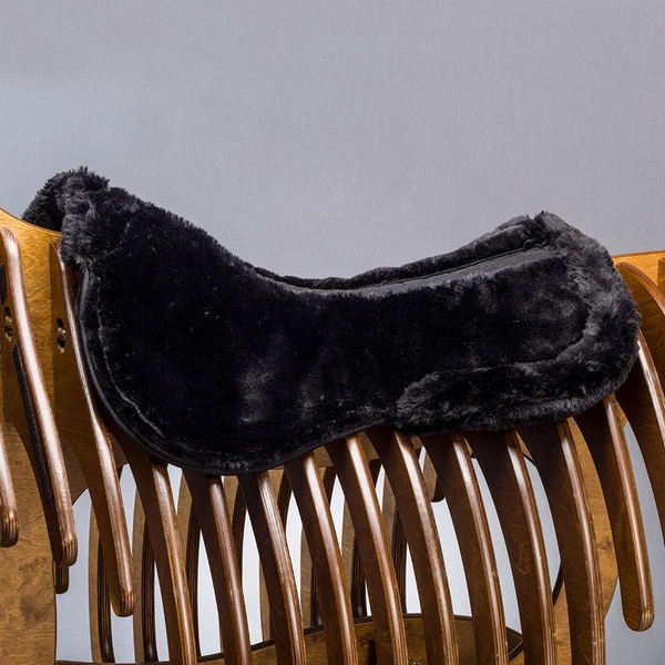 Black sheepskin saddle pad on rack