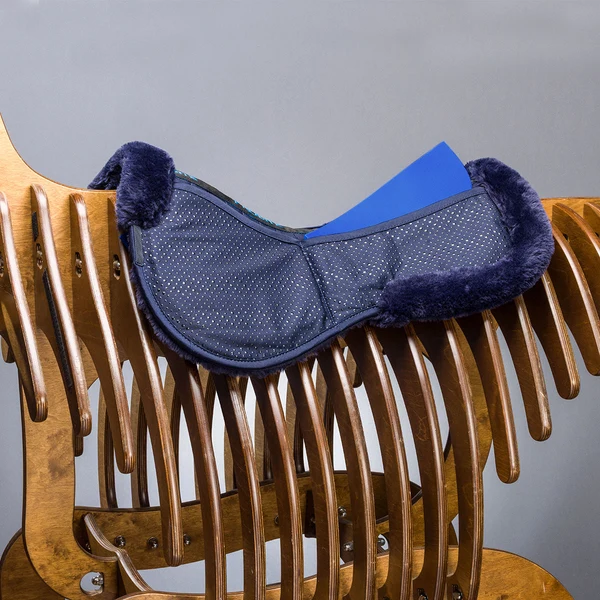 Navy saddle pad on wooden horse rack