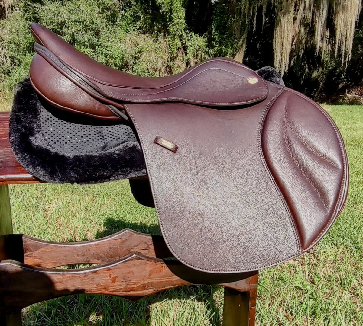 Brown saddle resting on a wooden surface.